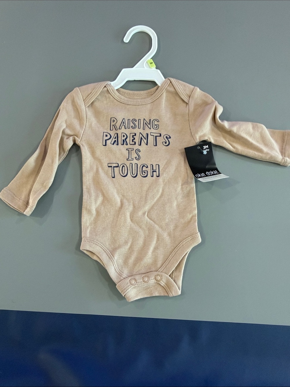 okie dokie Beige Long-Sleeve Baby One-Piece with 'Raising Parents Is Tough' Text